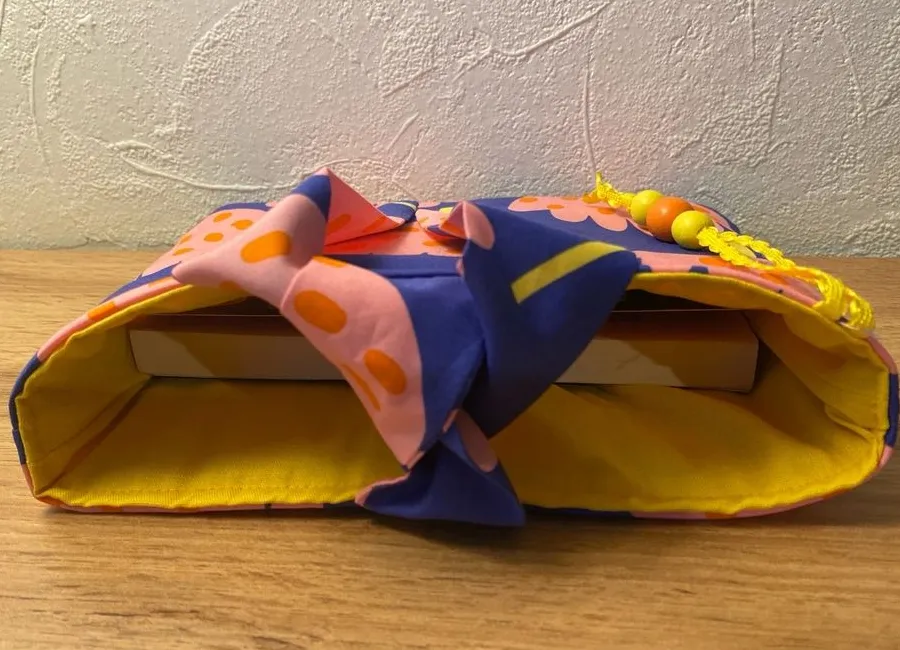 Vue de côté de la pochette pour liseuse en tissu bleu fleuri, finitions jaunes et perles cousues main par Créa'Flo