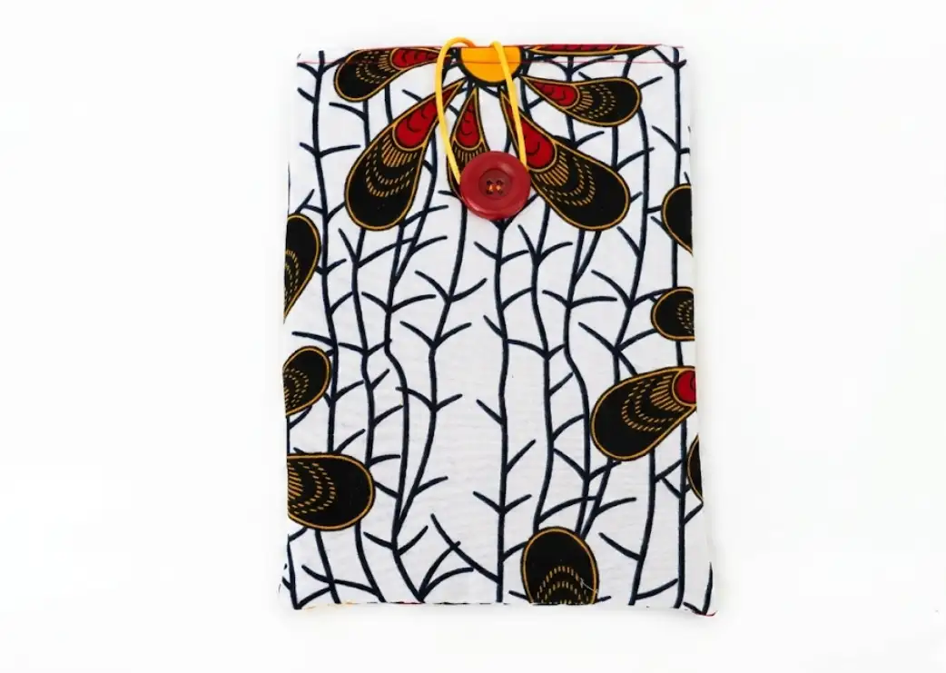 Housse liseuse tissu africain graphique vue à plat, motifs noirs rouge jaune sur fond blanc cousu main Créa'Flo