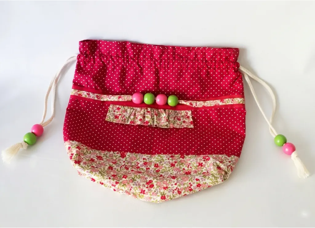 Pochon rouge fleuri vue du dessus, tissu pois blancs et bande fleurs rose, cordon perles fantaisie, Créa'Flo